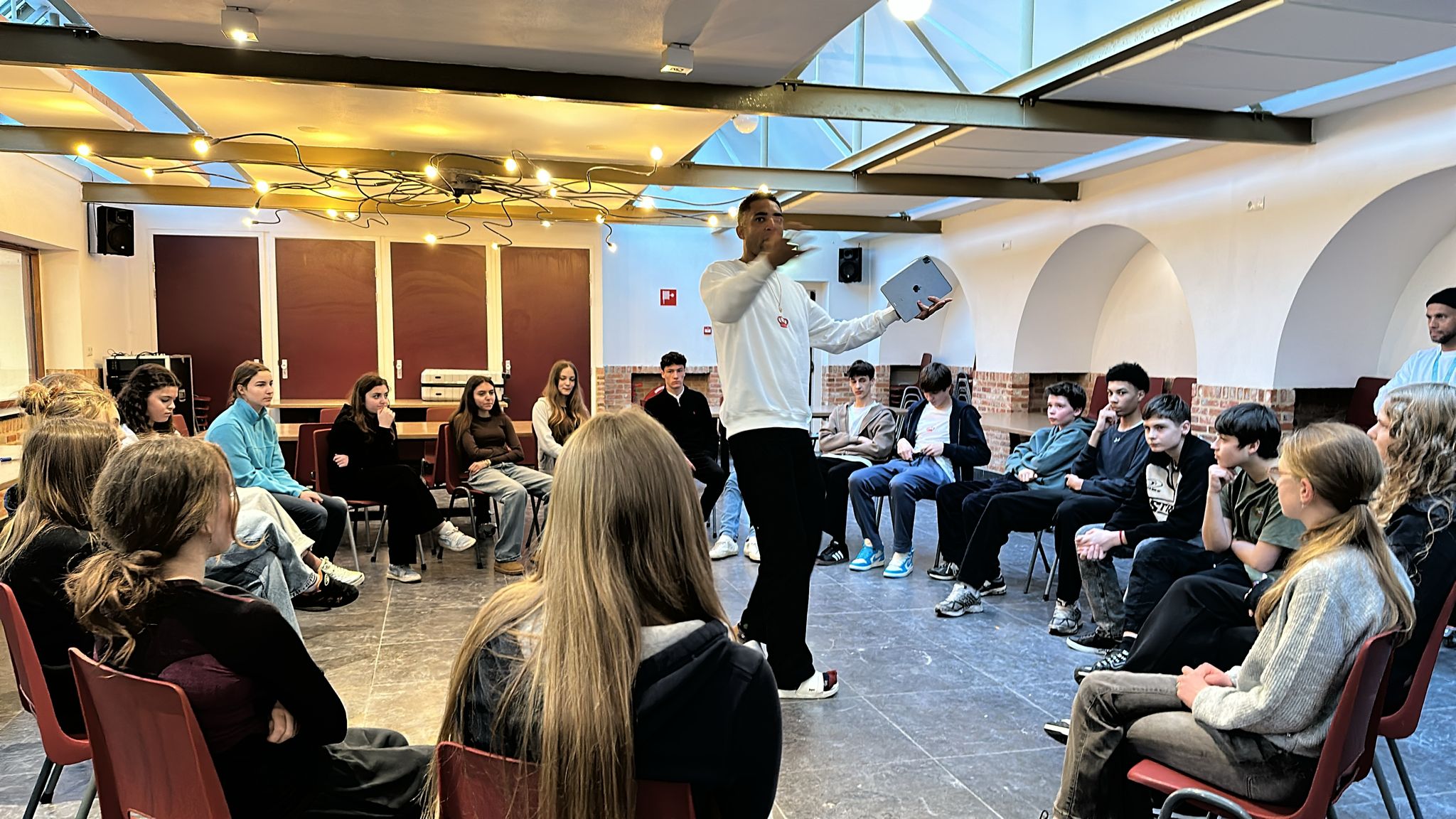 Welcome session — students seated in a circle in the main room, Simon addressing the group