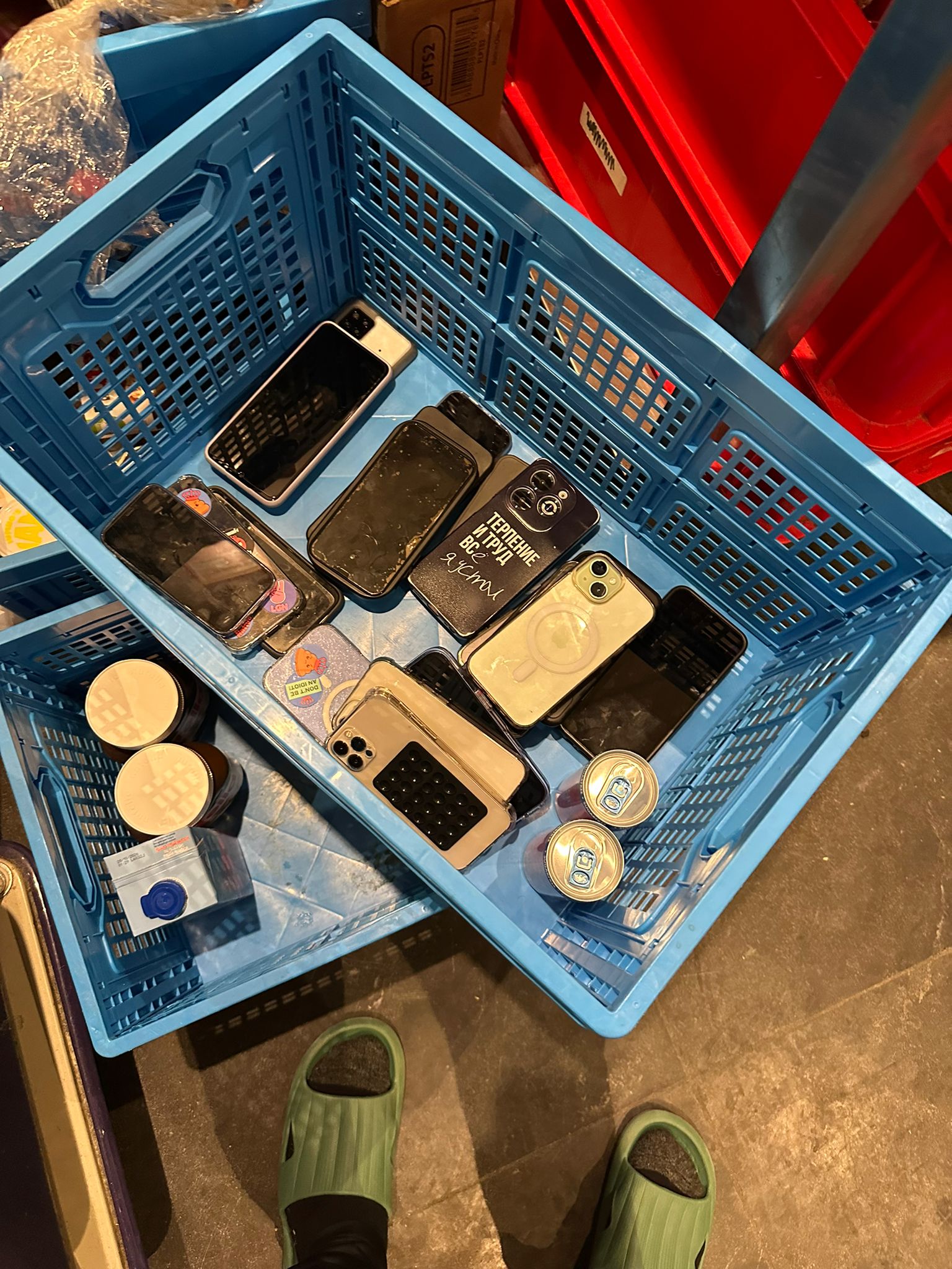 Blue crate containing confiscated phones and Red Bull cans