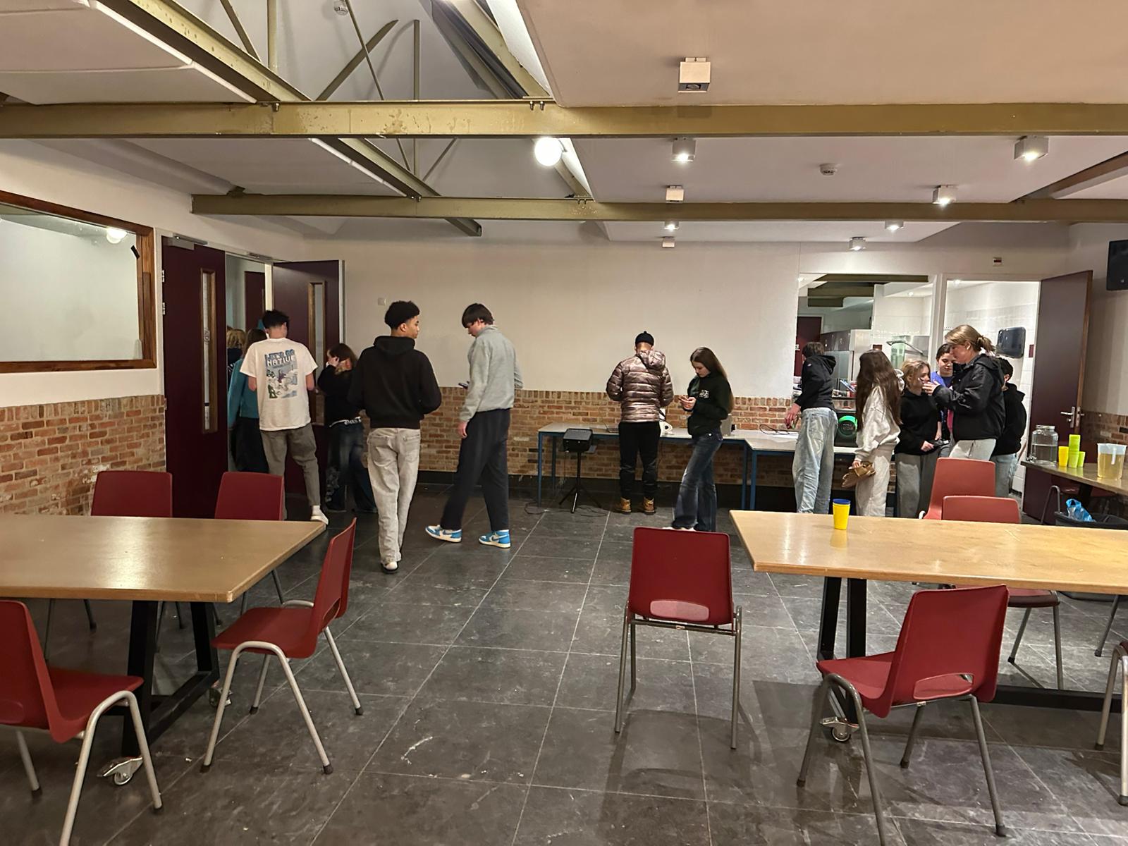 The main common room at Activestay — arched ceilings, brick walls, tables arranged for group activities