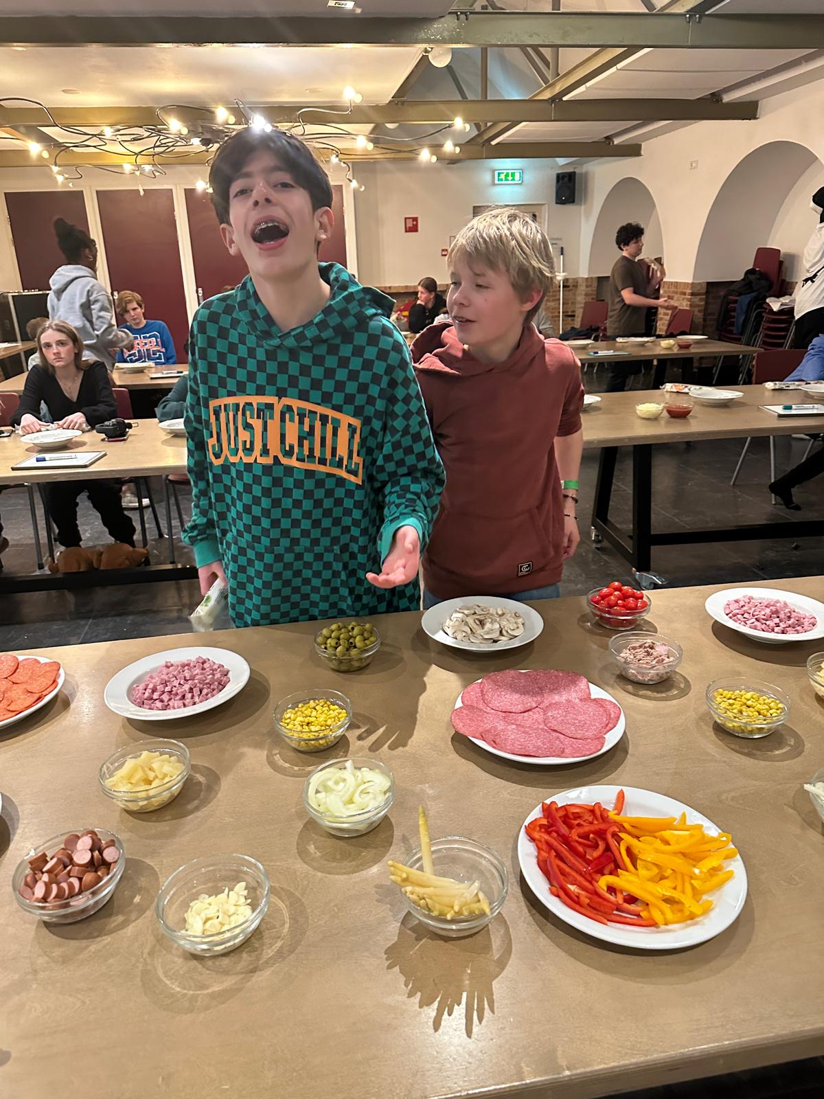 Students making pizzas in the industrial kitchen