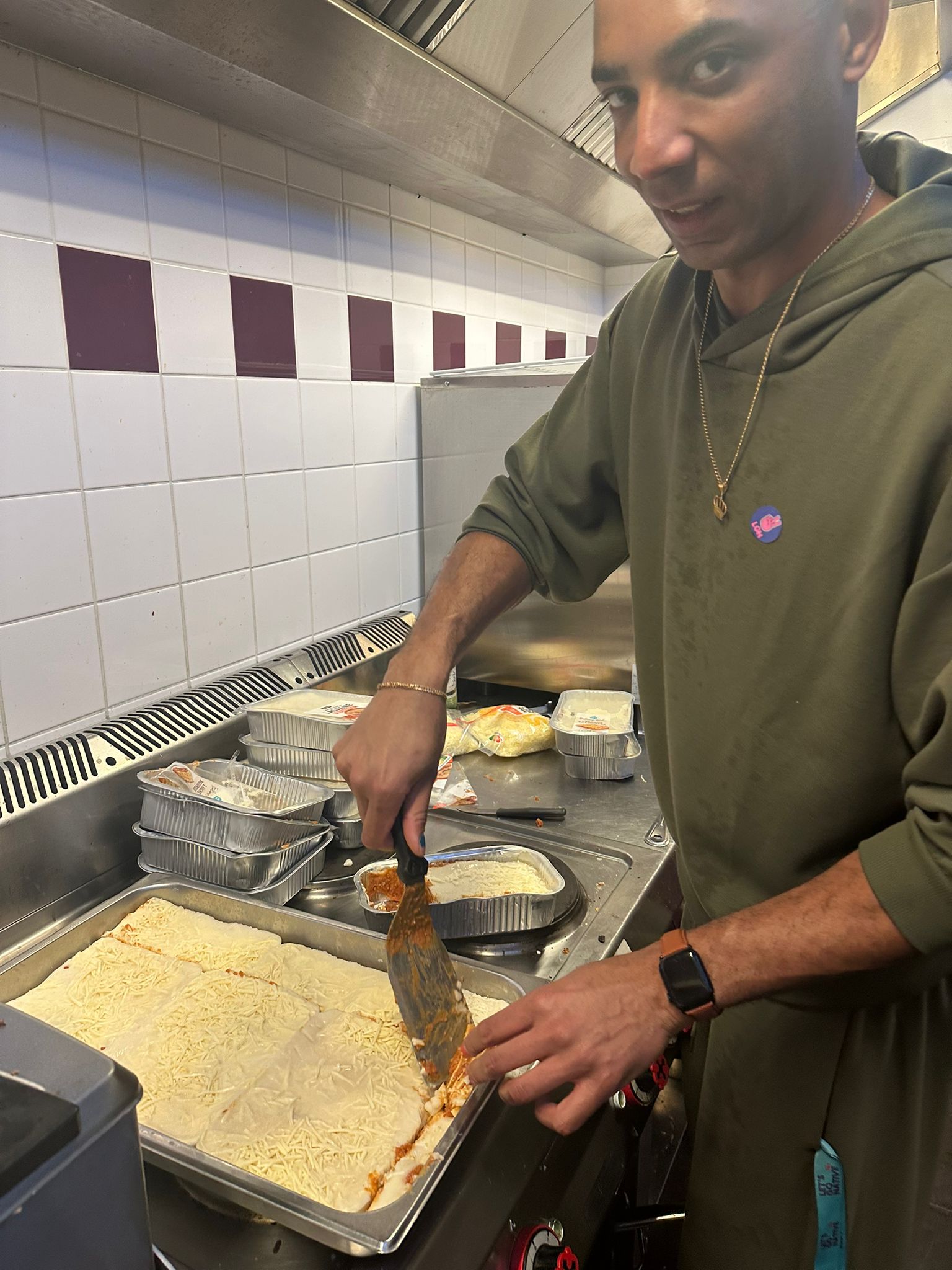 Facilitator preparing lasagna in the industrial kitchen