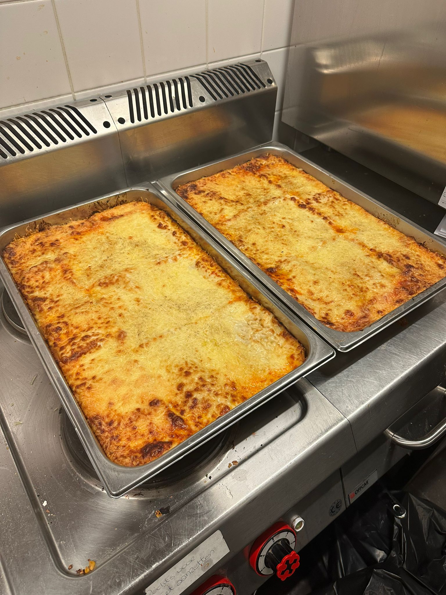 Two large trays of golden lasagna ready to serve